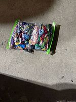 Clear resealable bag containing multiple skeins of embroidery floss in various bright colors placed on a carpeted floor.