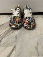 Front view of the colorful graffiti style sneakers showing the detailed abstract pattern and white laces.