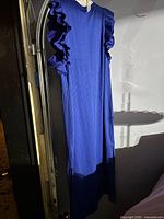 Blue H&M summer dress hanging, showing full front with ruffled sleeves and ribbed texture.