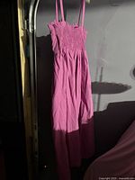 Pink long dress hanging showing full length and bodice details.