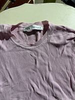 Close-up photo of pink ribbed Zara top showing neckline and fabric texture.