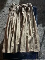 Full view of the Zara skirt showing its vertical beige and white stripes and pleated design.