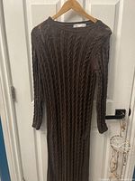 Full view of the brown Zara sweater style long dress hanging on wooden hanger