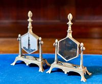 Frontal view of both brass stands with glass bottles installed, showing mirror and printed panel