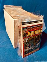 Long shot of white storage box filled with over 100 plastic-sleeved comics, front showing Adventure Into Fear with Man-Thing cover