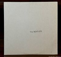 Front view of white album cover with 'The BEATLES' printed in black centered text