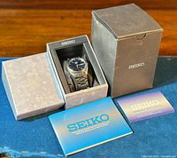 Full lot: watch in inner box alongside outer box, instruction manual, and guarantee card