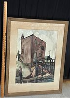 Framed watercolor painting with beige matting and wooden frame with ruler alongside showing size.