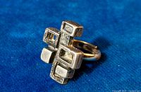 Angled side view of the pewter ring, showing the chunky brutalist geometric abstract design with varying rectangular and square elements and the adjustable band.