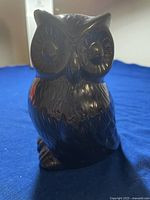Full front view of black ceramic owl ornament showing detailed feather texture and facial features.