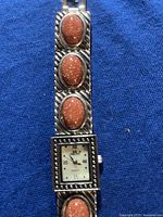 Close-up view of the watch face and decorative brown glittery stones on the band.