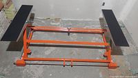 Main hydraulic frame and two black rubber platforms on concrete floor