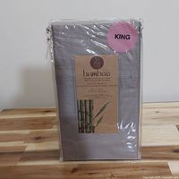 Photo of unopened package containing two grey king size pillow cases made from bamboo viscose fabric.