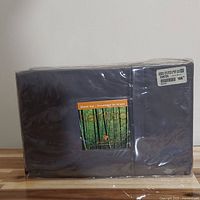 Front view of the vacuum-sealed sheet set package in a dark color.