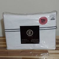 Clear plastic packaged white king size sheet set with subtle grey stripes and Firenze branding on the label