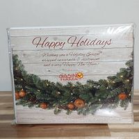Front view of packaged queen sheet set showing holiday greeting and brand Casino Rama.