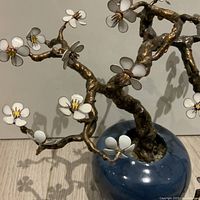 Close-up of copper branch and white enamel flower
