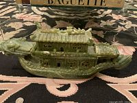 Side profile view of jade boat sculpture showing dragon head prow, cabin and tail section