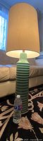 Full-height shot of lamp with shade and water bottle for scale