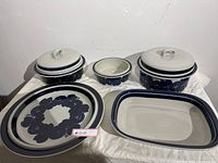 Full set of Arabia Finland stoneware including plates and cooking dishes with lids, showing overall lot contents and condition.