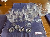 Top view of all crystal glasses and sugar bowls with spoons arranged on a blue cloth.