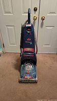 Front view of Bissell ProHeat 2X carpet cleaning machine showing upright design and water tank.