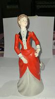 Front view of the Coalport Ladies Of Fashion "Alice" figurine showing the woman's facial features and red jacket with black lapels.