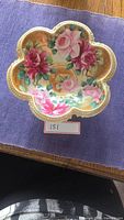 Top view showing scalloped edges and floral pattern with pink and red roses and gold detailing.