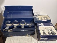 Three larger glasses in open blue Thomas Glas box alongside two smaller boxed sets