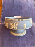 Top and side view of Wedgwood blue Jasperware sacrificial pattern bowl with white classical relief decoration, showing overall shape and design.