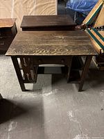 Front view of the antique dark brown wooden desk showing the drawer and shelf design.