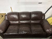 Front view of three-seat brown leather couch