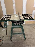 Front view of the green Craftex table saw showing the tabletop with grid-like surface and adjustable fence.