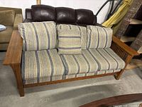 Front view of wooden framed couch with striped fabric cushions