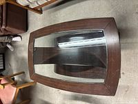 Top down view of wood and glass coffee table showing rectangular glass inset and wooden frame.