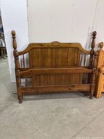Full view of the rustic wooden headboard and footboard connected with rails, showing the overall design and brown wood finish.
