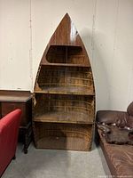 Full front view of boat-shaped shelving unit showing four curved compartments