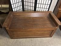 Closed view of the brown wooden hope chest showing the rustic finish and scratches.