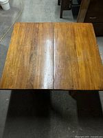 Top view of the wooden table showing the wood grain, split tabletop with no insert, and light stain finish.