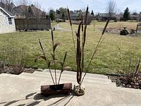 Both metal sculptures arranged on concrete steps with backyard background