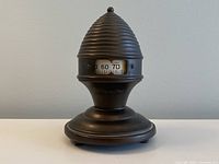 Front view of the antique Therm-o-Dial thermometer showing the beehive-shaped top and temperature window.