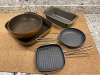 Photo showing the set of 5 items: 2 ceramic baking pans (round and rectangular), metal loaf pan, and 2 small non-stick skillets (round and square).