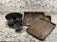 Overview of the 5 inch and 10 inch bundt pans in front of 3 baking sheets and a cooling rack on top
