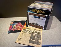 Bankers box filled with roughly 45 vinyl LP records, Boston album visible on top