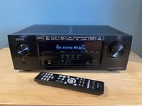 Front view of Denon AVR-S530BT with status display on, remote in front