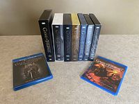 Complete set of Game of Thrones seasons 1-8 and Conquest & Rebellion animated Blu Ray, showing all box sets and cases upright with the text visible.