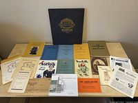 Photo of multiple historical publications including the large hardcover atlas and various smaller booklets and a CD relating to Norfolk County history.