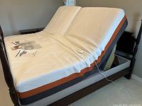 Angled view of adjustable foundation raised with mattress bending at head and foot