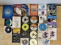 First photo shows multiple software programs including Microsoft Windows XP Professional box, Adobe Photoshop Elements 8 and 2019, Adobe Premiere Elements 8, Roxio Creator software in original packaging, and multiple CDs for different software.