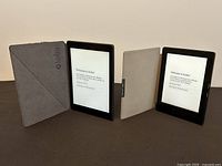 Two Kobo e-readers in grey and black folio cases side by side, screens on to ‘Welcome to Kobo!’